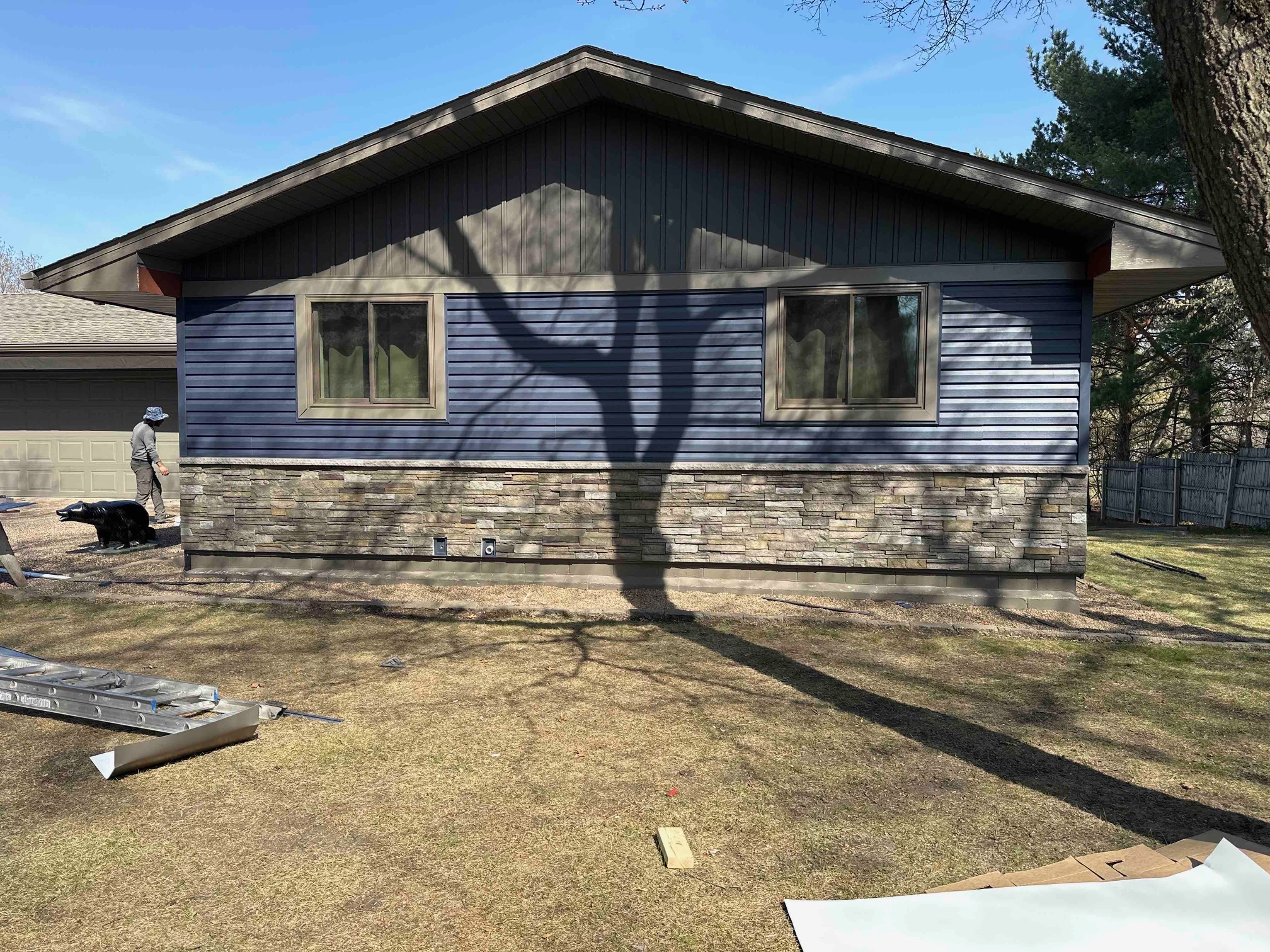 Blue sided home with new roof installation