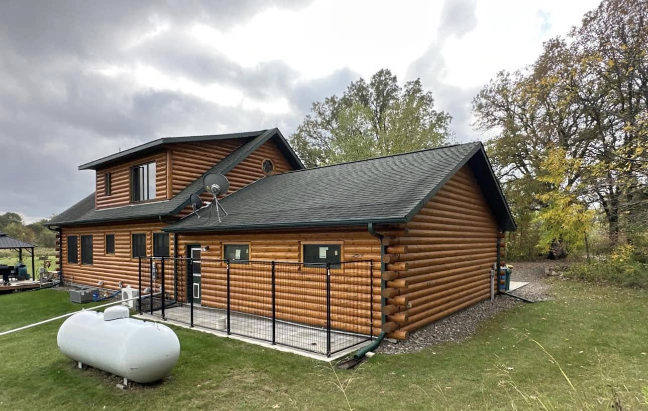 Log cabin home with new dark metal roof